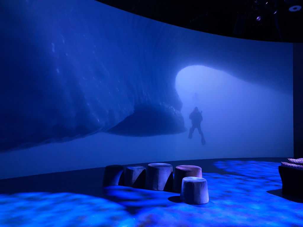 Large video screen of diver Mario Cyr in Arctic.